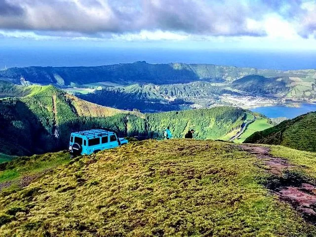 Jeep bleu sur une colline herbeuse surplombant les lacs de Sete Cidades.