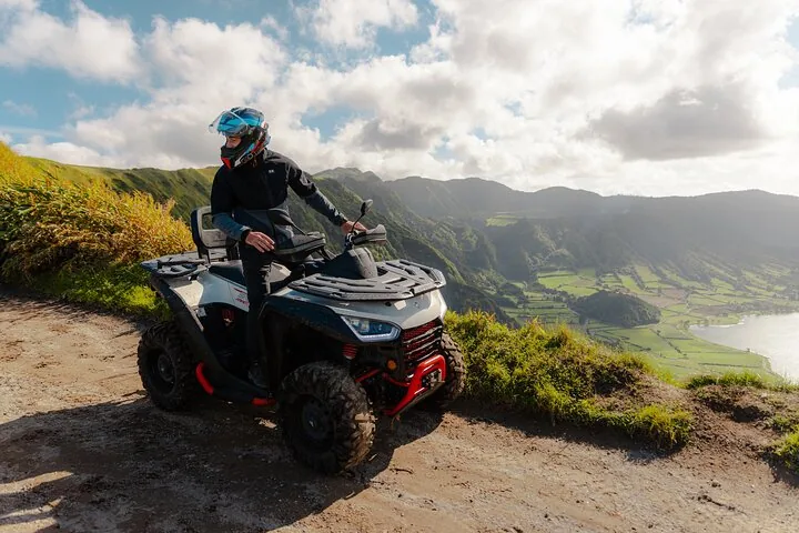 Person auf einem ATV, die auf einem Schotterweg hält und die Seen betrachtet.